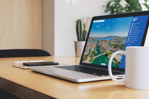 Workspace with a Notebook on table showing the Aumivi Web-App of the Greater Zurich Area